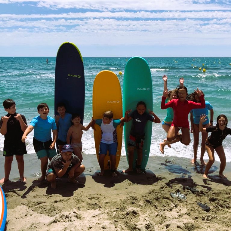 Niños con tabla de surf en la playa